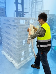 Jerema Ma, EOS account manager, labels boxes on a pallet while preparing outbound freight for shipment.