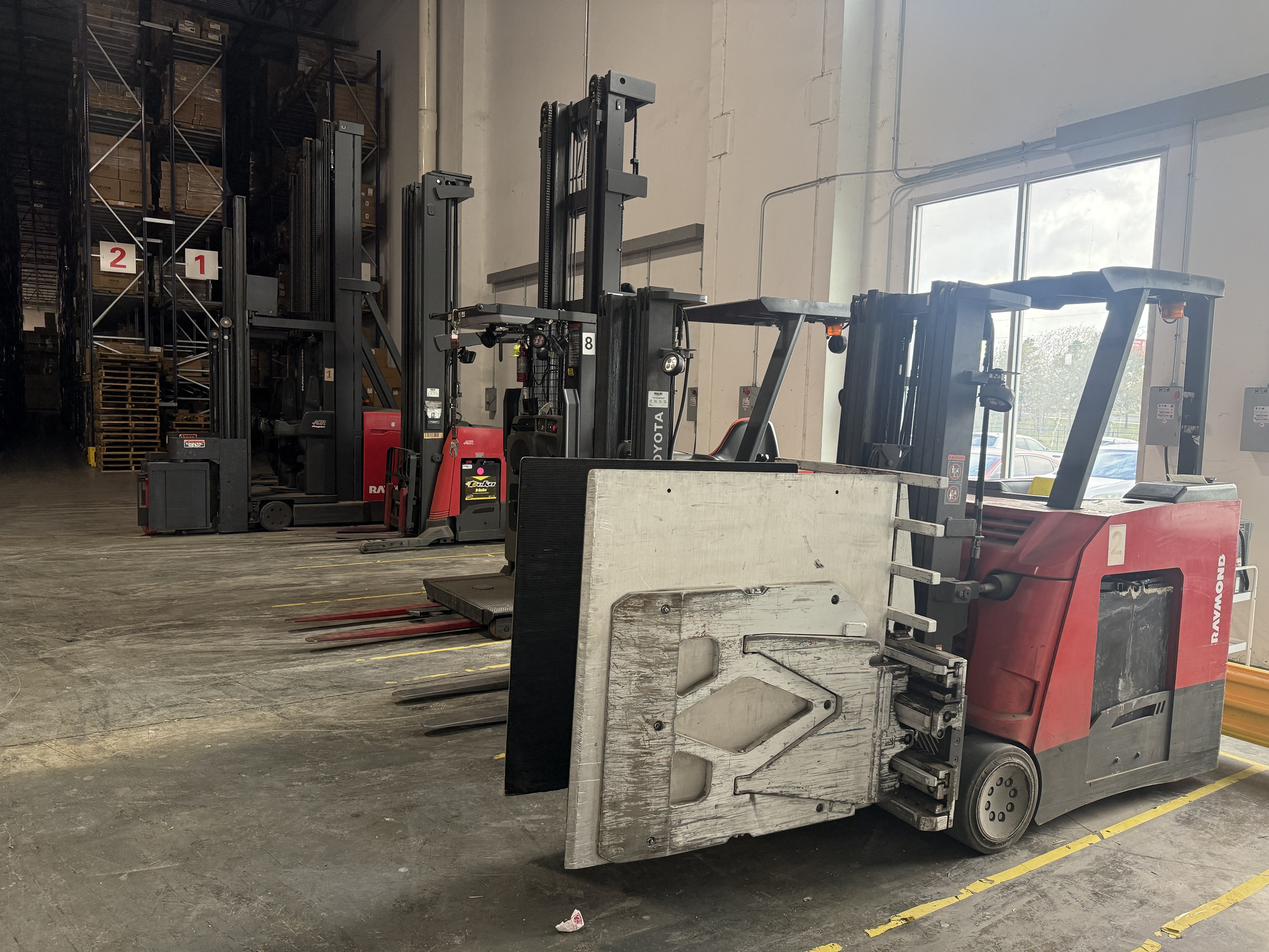 Warehouse equipment including clamp forklifts and handling machines at EOS Southeast Region Warehouse.