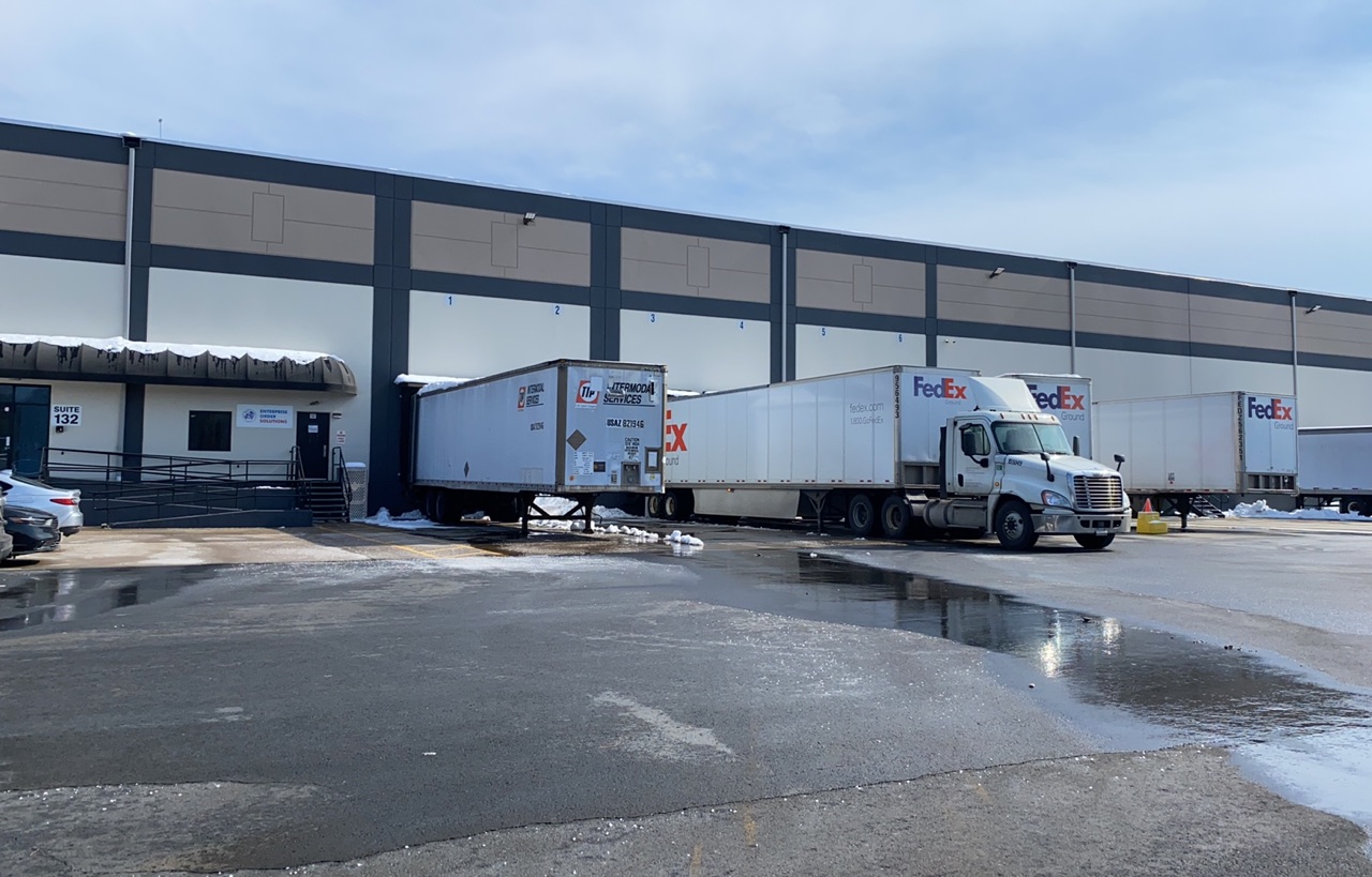 EOS Northeast Region Warehouse outside docks showing FedEx containers at the dock in Dayton New Jersey.