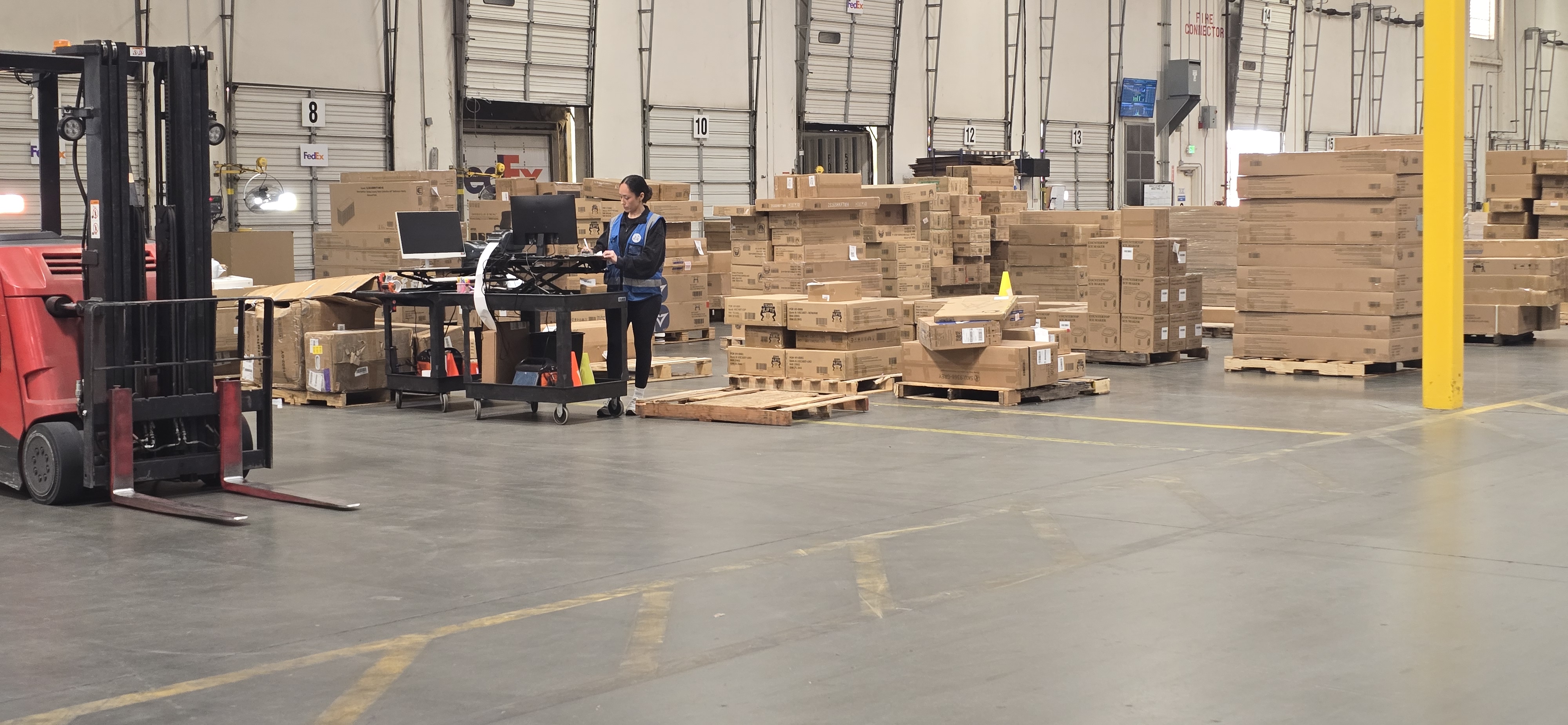 Worker in staging area checking order status inside EOS Southern California Warehouse.