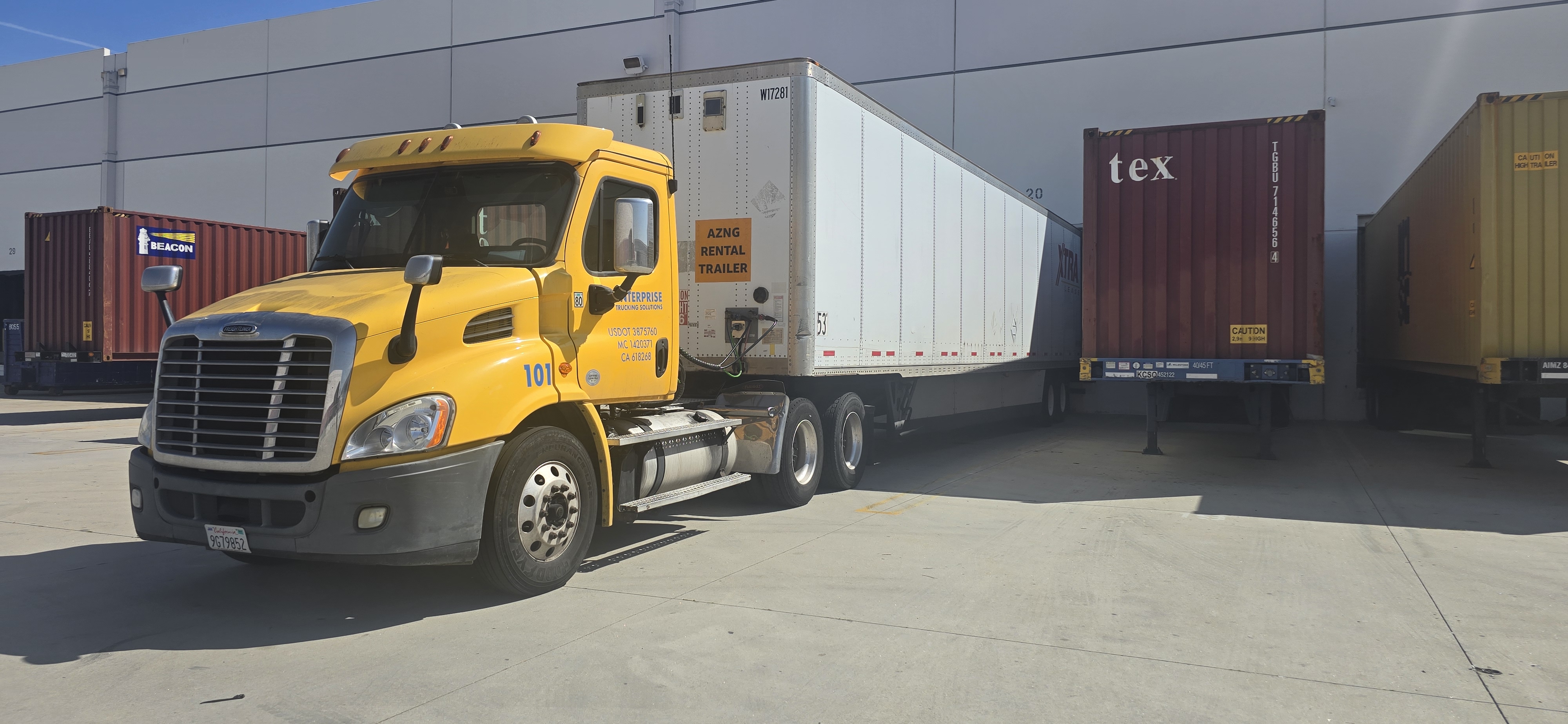 Yellow ETS tractor and trailer at an EOS warehouse dock, with containers alongside.